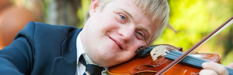 A person with Down Syndrome plays the violin. 