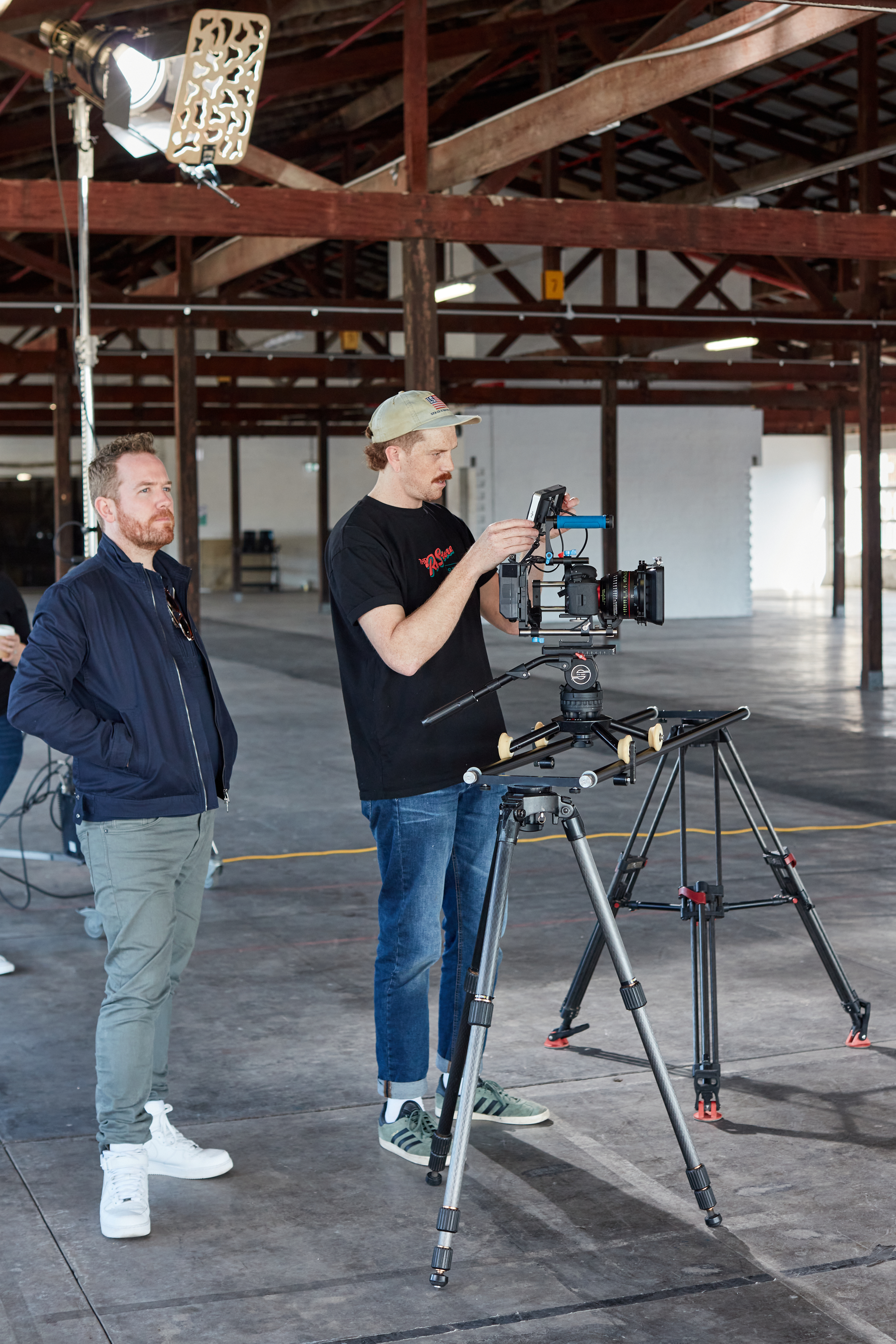 2 men stand on set of Perspective Shift checking cameras